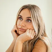 Portrait of a blonde woman resting her chin on her hand