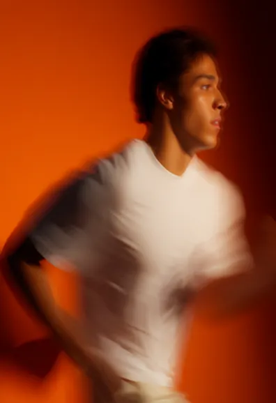 Portrait of a person in a white shirt against an orange background