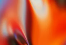 Abstract blurred gradient forming a curved arc of teal and purple against warm orange and peach tones, resembling a swirl of colored light.