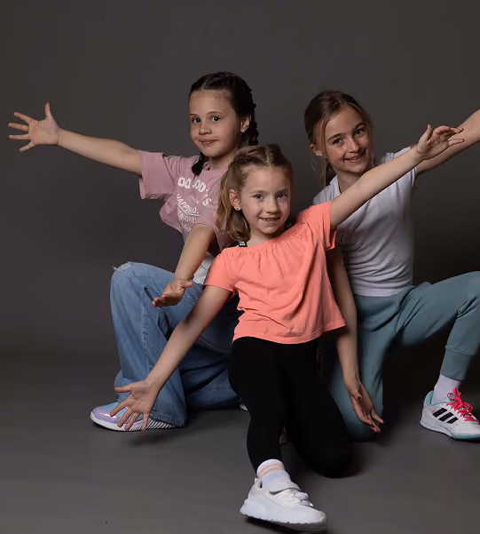 Drei Kinder posieren als Tanzgruppe.