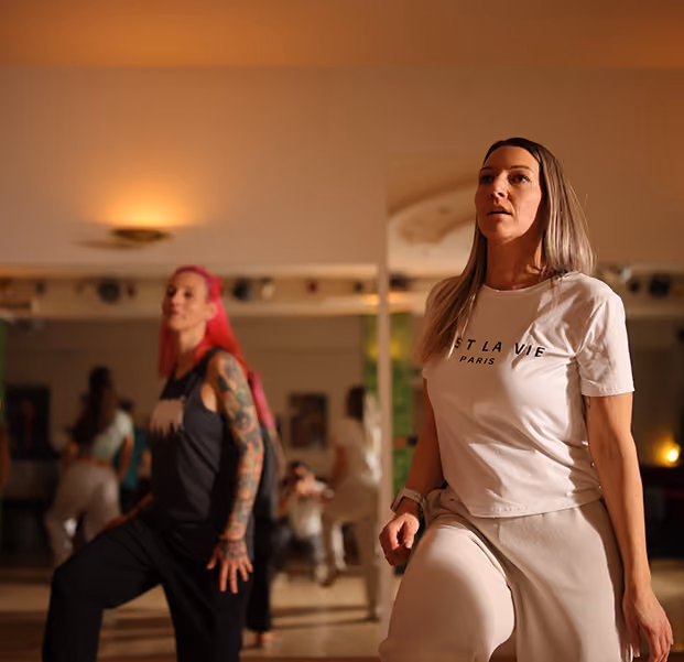 2 Frauen tanzen Hip-Hop in einem Tanzstudio mit Spiegel.
