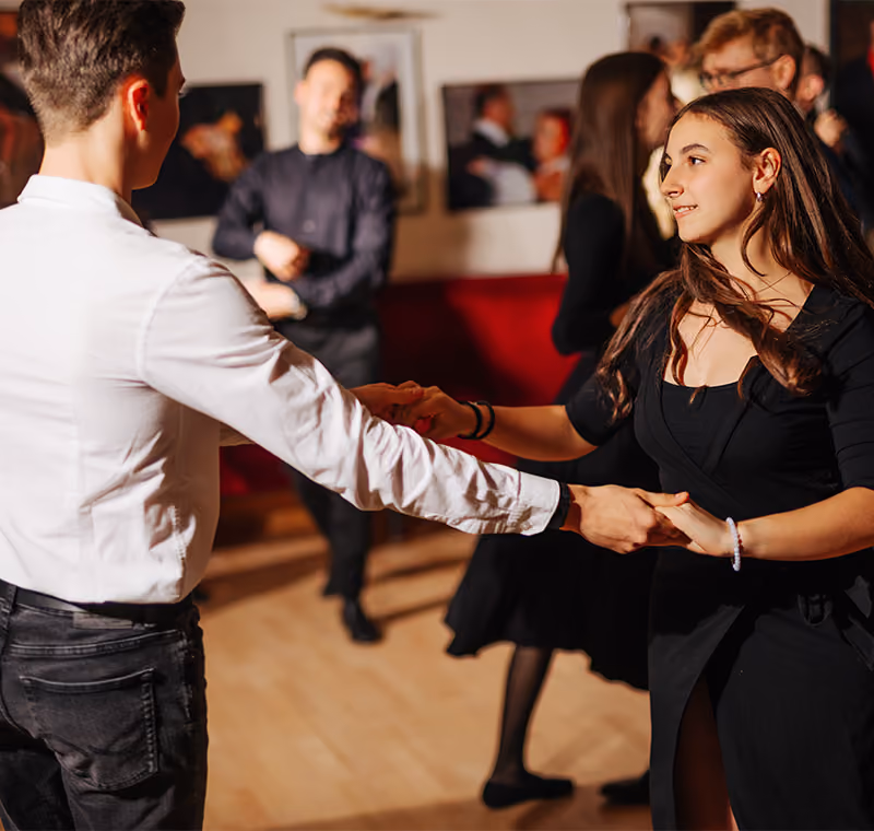 Mehrere Paare tanzen gemeinsam in einer Tanzschule.