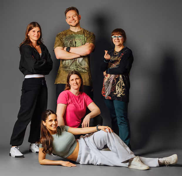 Mehrere Mitglieder der Tanzschule Dietrich posieren vor einer Fotowand.