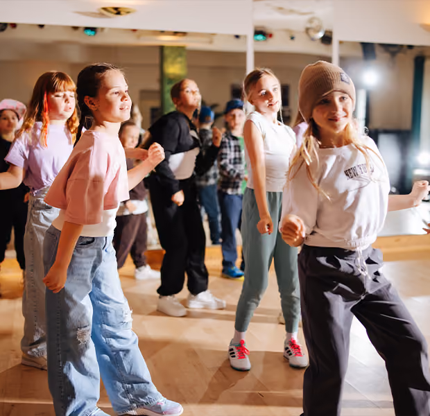 Eine Gruppe Kinder übt Hip-Hop Tanzschritte.