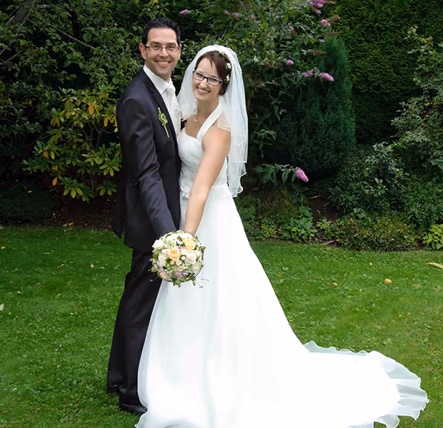 Hochzeitspaar bei einem Fotoshooting im Freien.