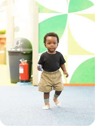 Toddler walking through an indoor play area