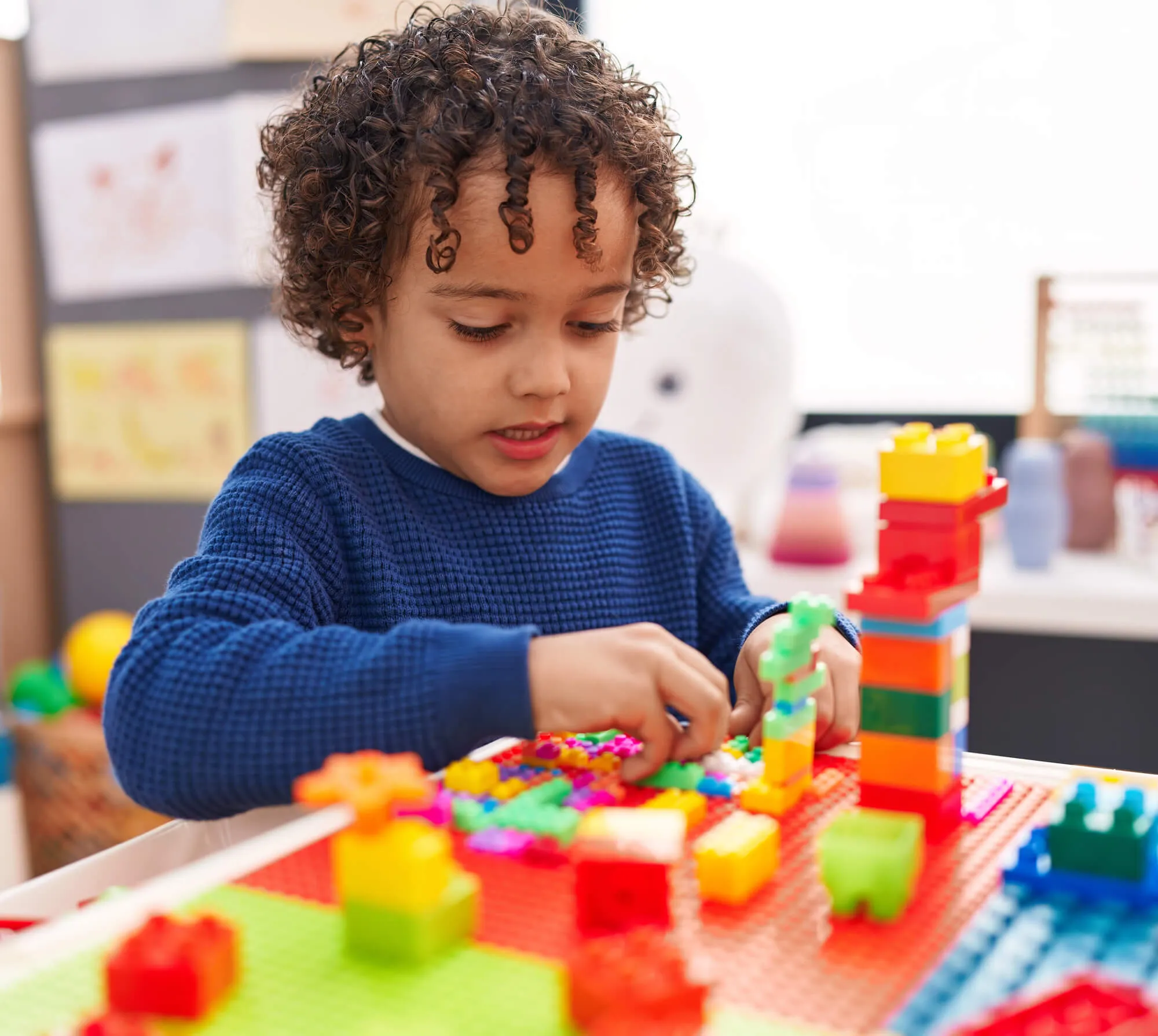Young boy building a tower with colorful toy blocks