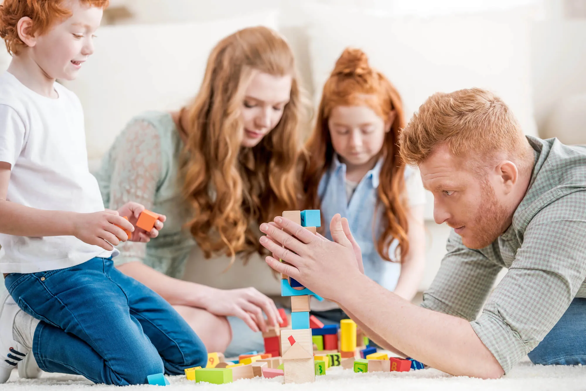 Family building a tower with colorful blocks together