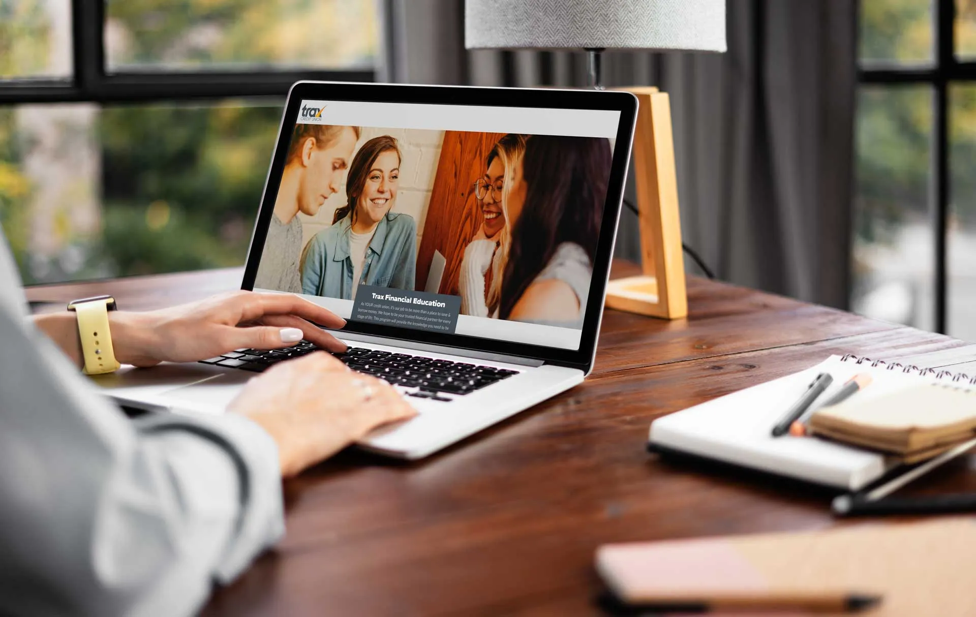 Person using laptop showing a financial education webpage with a group photo displayed.