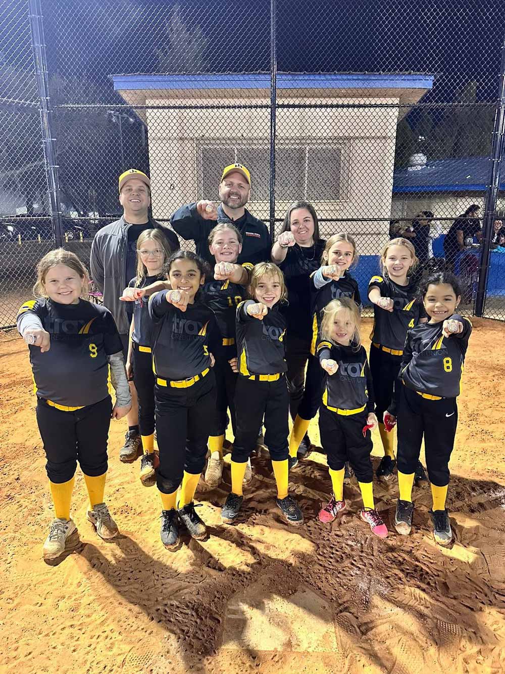 Trax sponsored youth softball teams posing with their team.