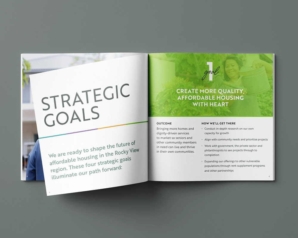 Open booklet displaying strategic goals with a focus on affordable housing in the Rocky View region: page on left titled 'Strategic Goals' with text about shaping affordable housing future; right page highlights goal 1 to create more quality, affordable housing with heart, including outcome and steps to achieve it.