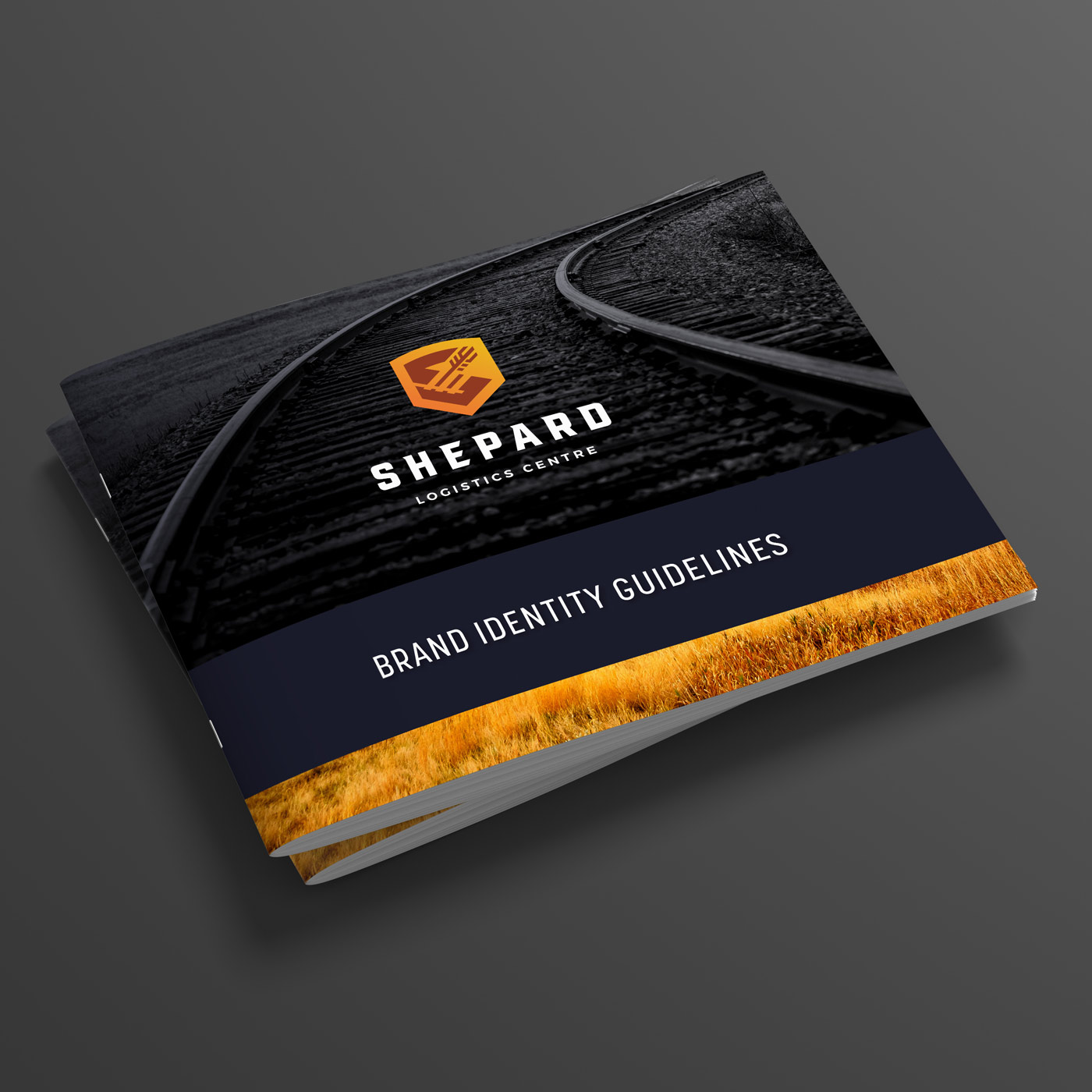 A booklet titled 'Brand Identity Guidelines' for Shepard Logistics Centre, featuring a cover image of curved railroad tracks with the Shepard logo above the title in white text on a black background, and a strip of golden grass at the bottom.
