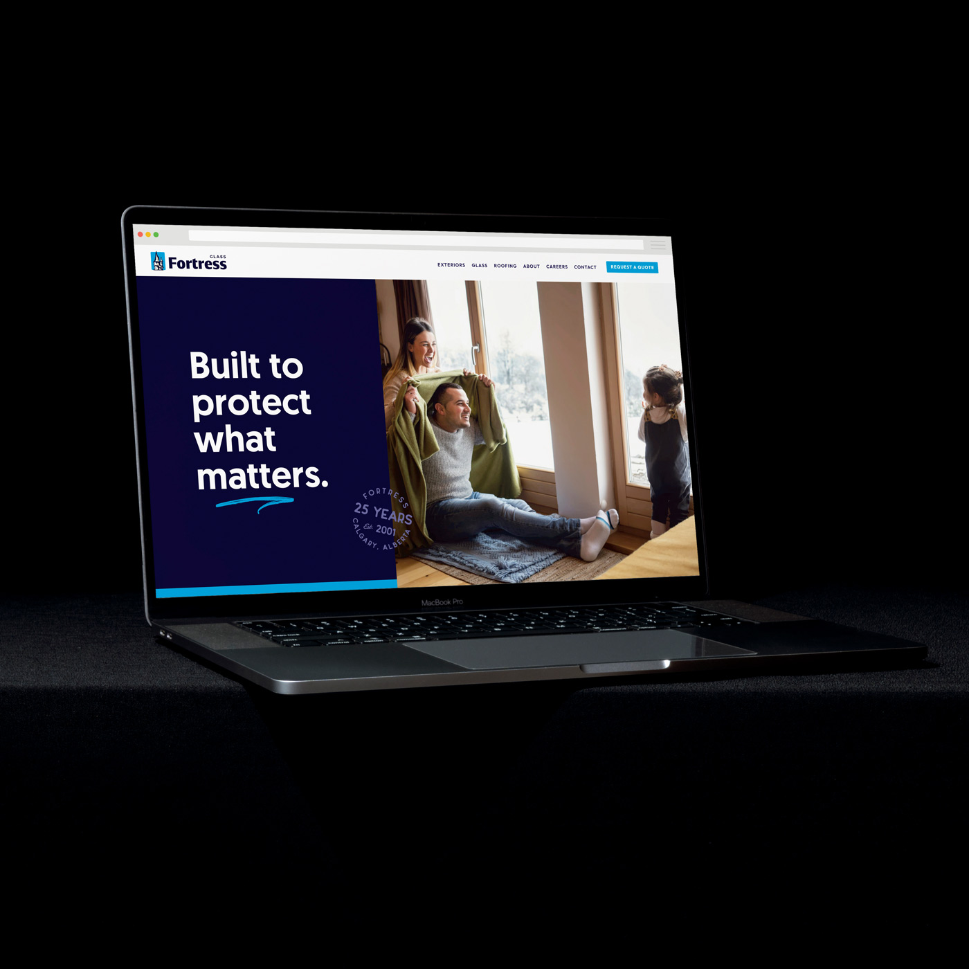 MacBook Pro laptop screen displaying Fortress Glass website with a family scene and tagline 'Built to protect what matters.'
