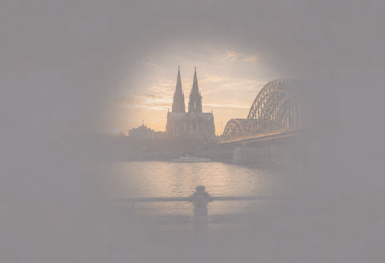 Kölner Dom und Hohenzollernbrücke bei Sonnenuntergang, Spiegelung im Rhein, dramatischer Himmel.