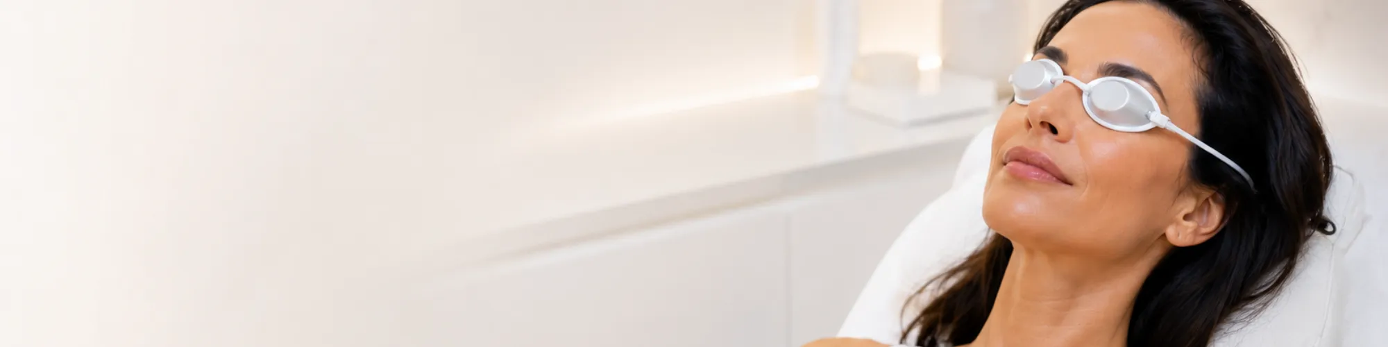 Femme se relaxant avec lunettes de protection lors d'un soin de peau en institut.