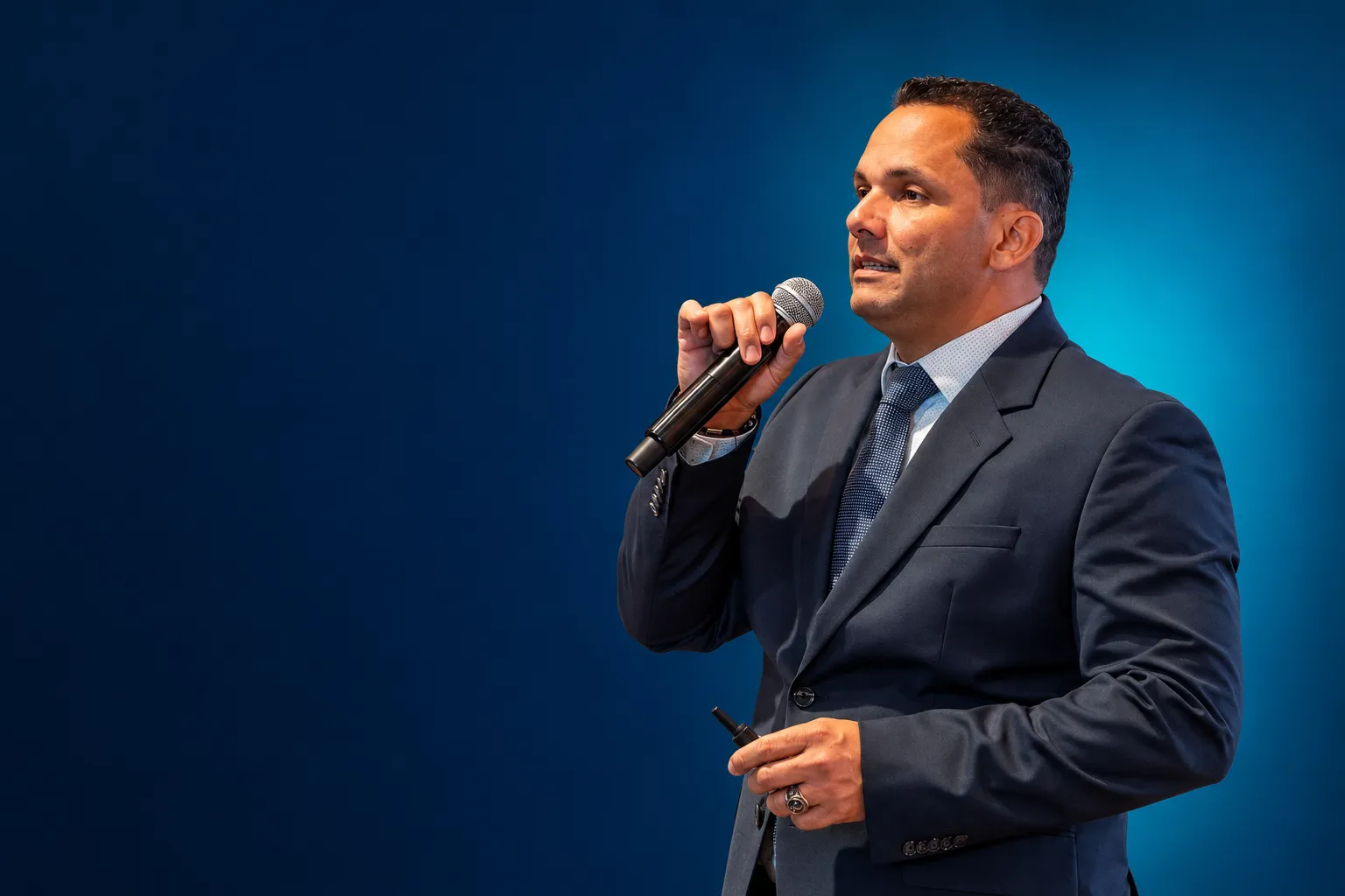 Dr. Gilberto Crespo speaking with a handheld microphone