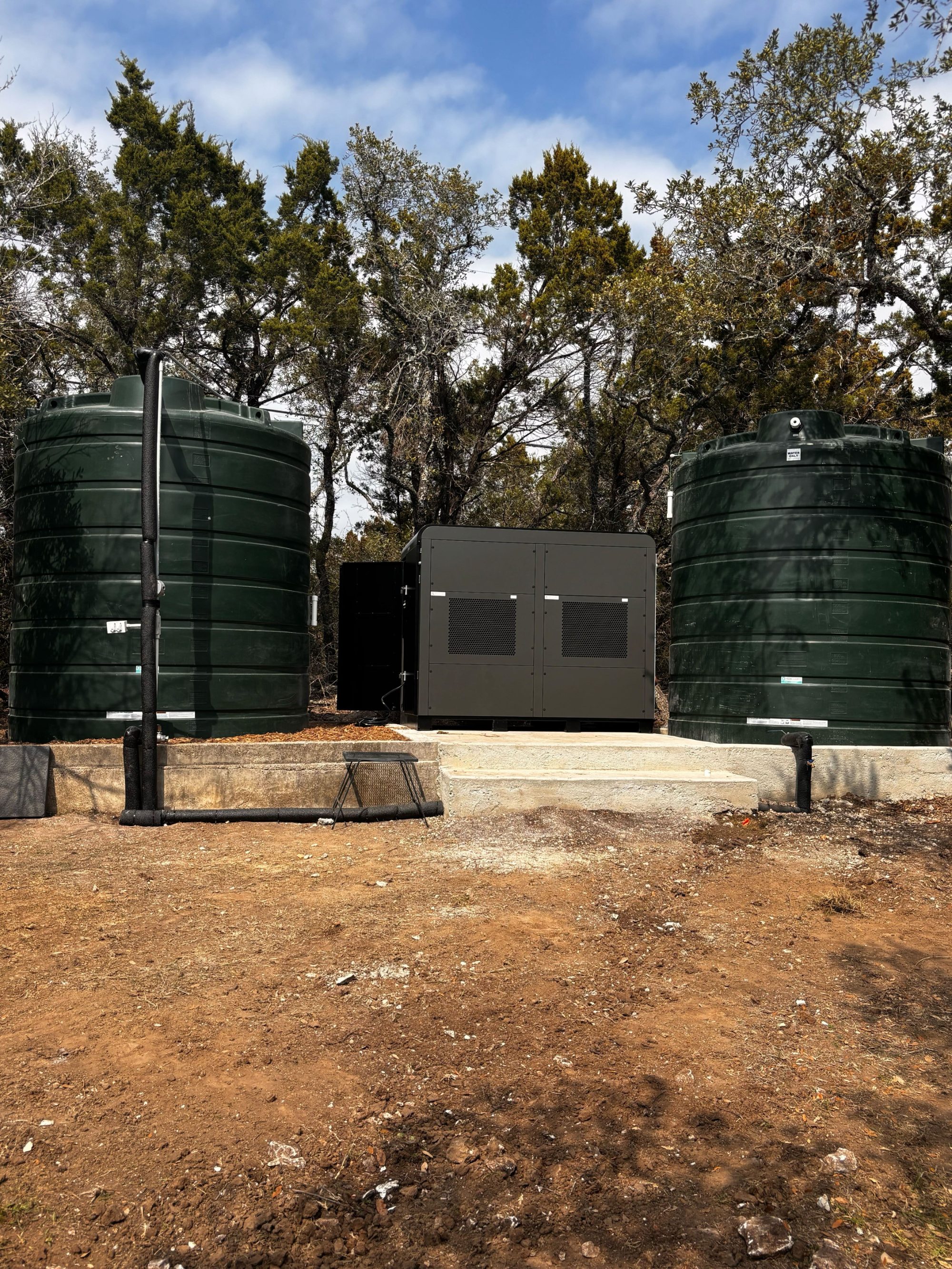 Hydropack X on a concrete pad between two water storage tanks