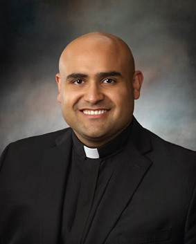 Father Elmer Herrera-Guzman smiling in clerical collar portrait