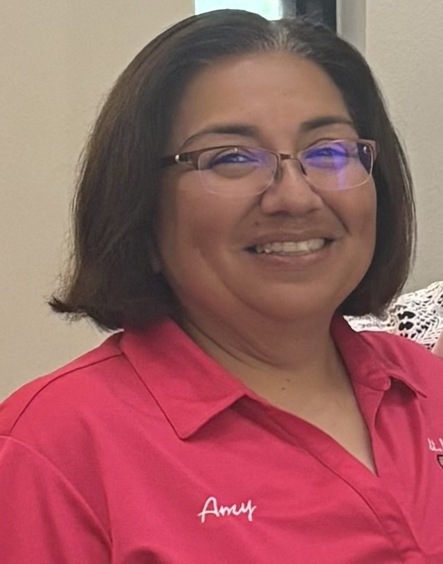 Amy Ocampo smiling in a pink staff polo shirt