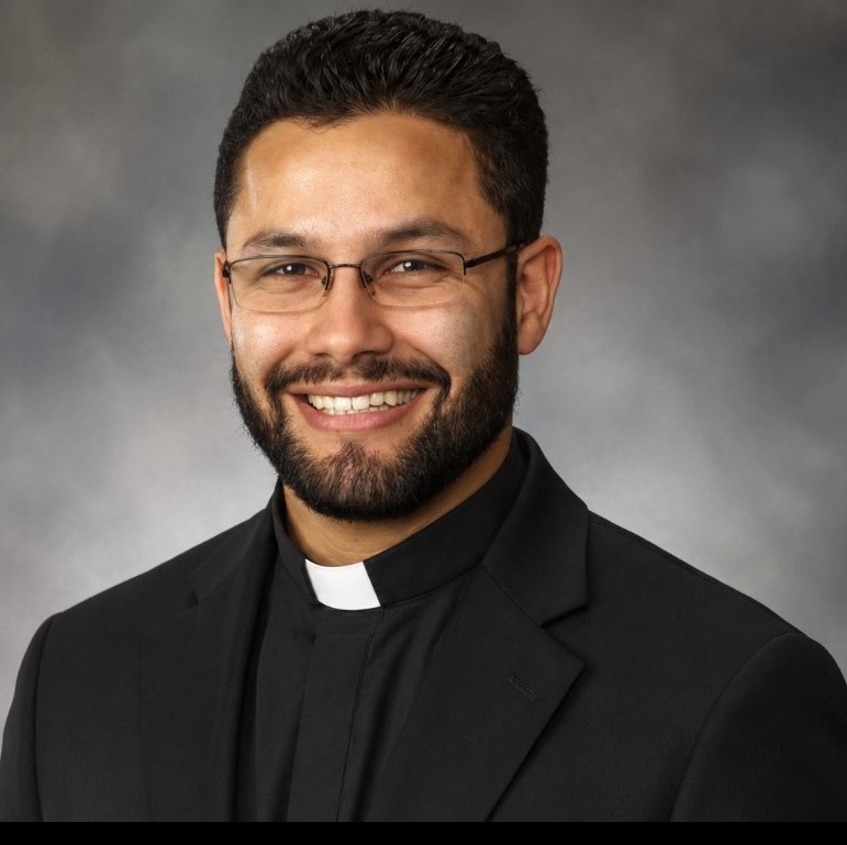 Father Felipe Vives smiling in clerical collar official staff portrait