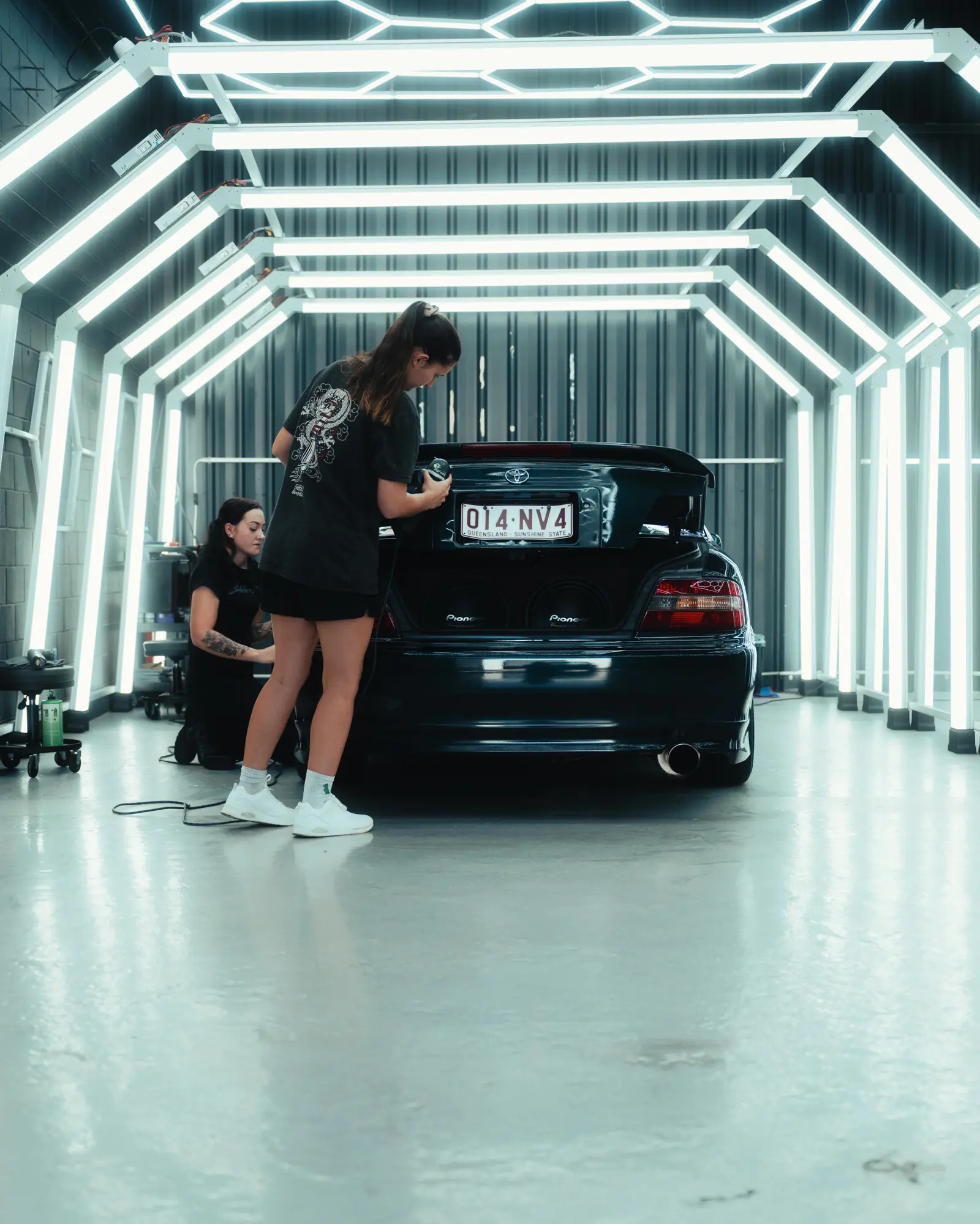 Layni, owner of Ghostline, working with the team to detail an EH Chaser in the workshop under white paint inspection lights