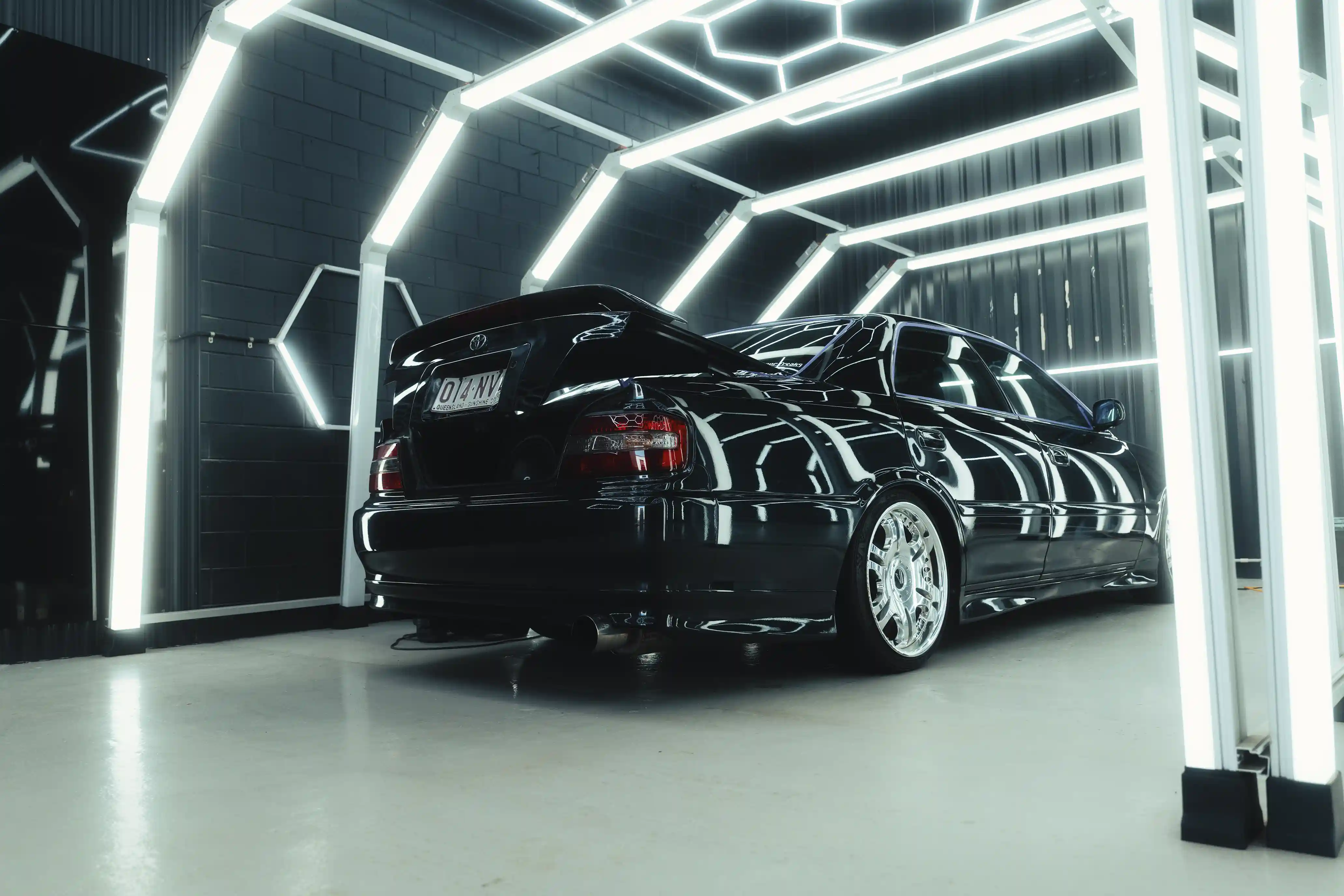 Rear view of an EH Chaser under paint inspection lights with the boot lid open