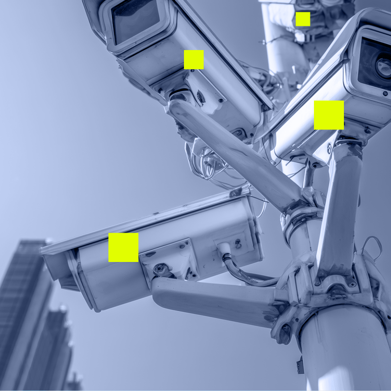 Multiple security cameras mounted on a pole pointing in different directions under a clear sky.