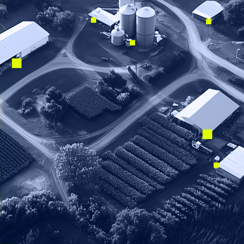 Aerial view of farm fields, silos, and multiple agricultural buildings connected by dirt roads.
