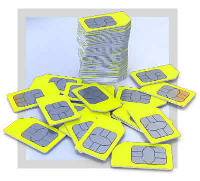 Stack and scattered yellow SIM cards with metallic chip contacts on a light surface.