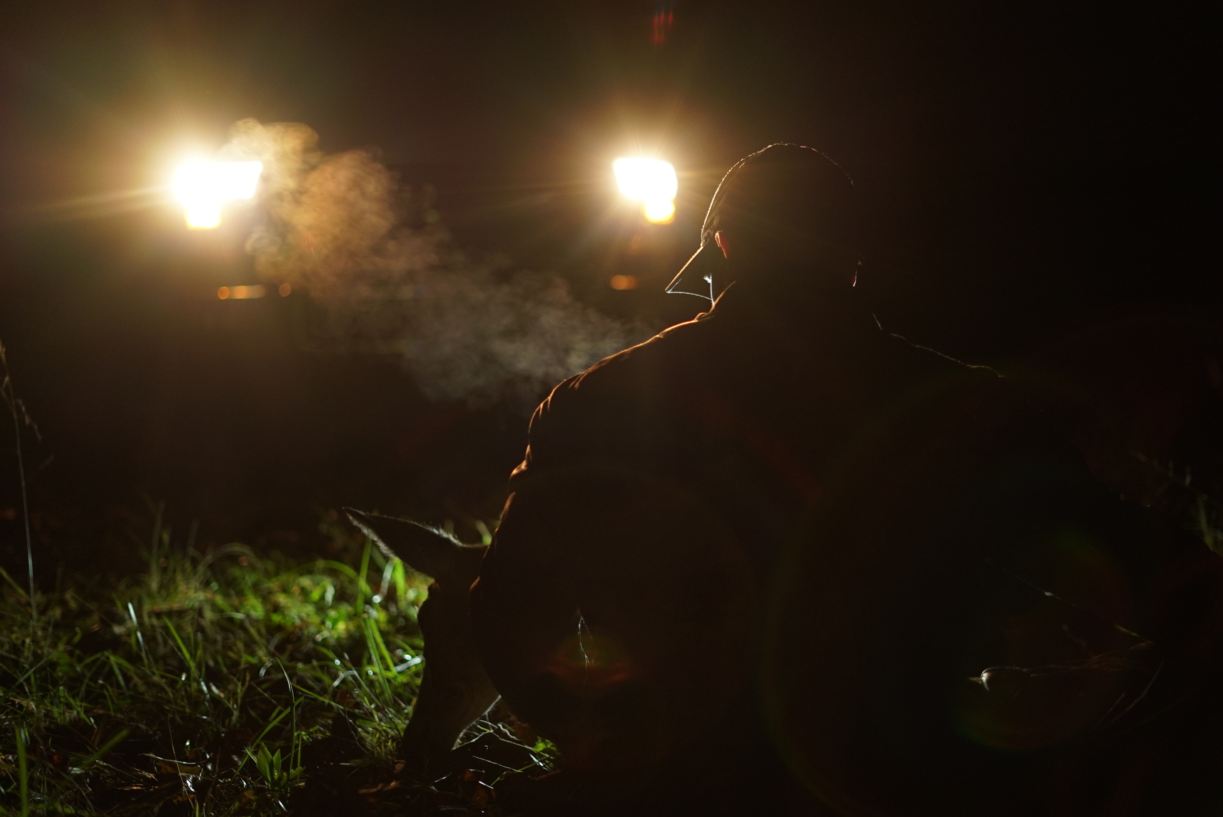 A hunter successfully locating his harvested whitetail deer in thick brush at night, utilizing precise coordinates provided by 24/7 drone night tracking services.