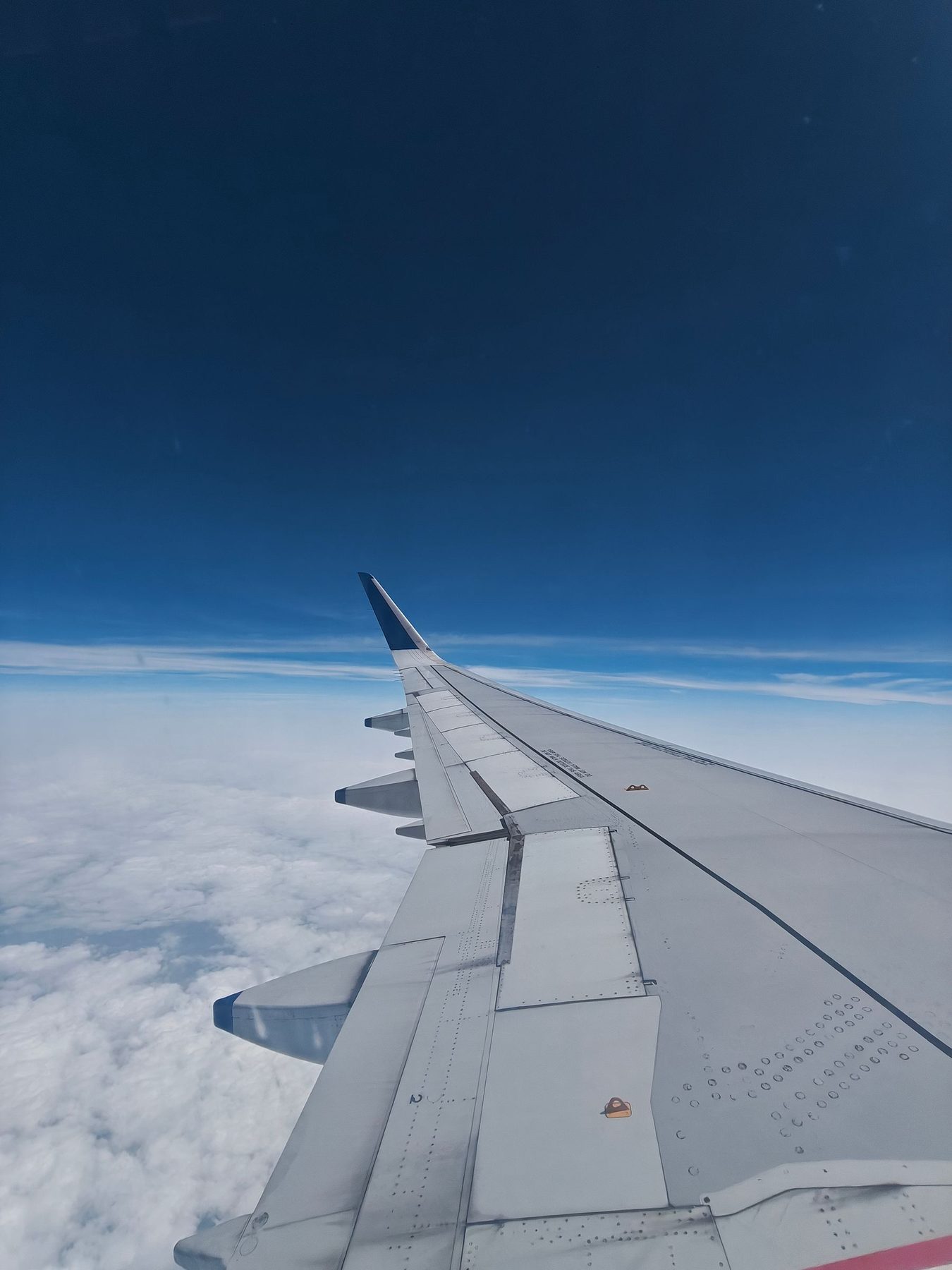 An airplane wing above the clouds