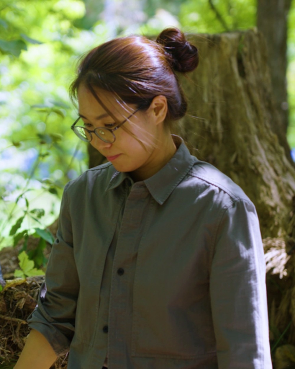 숲속 그루터기 곁에서 어린 식물을 살피는 정원 작가 김단비