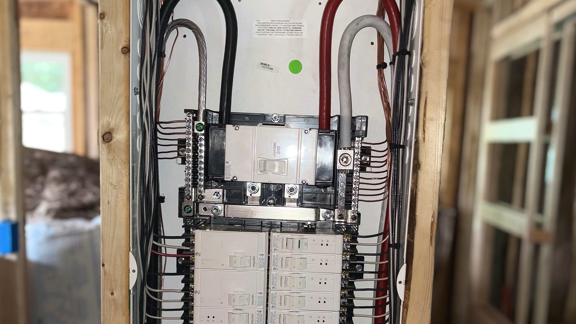 Licensed electrician installing a Leviton residential electrical panel during rough-in in the Charleston WV area.