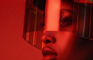 Close-up of a person's face with a red translucent visor covering their eyes and forehead.