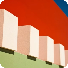 Five rectangular blocks in a row against a red and blue background with a green base.
