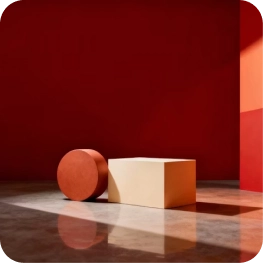 Red circular and beige rectangular blocks on a reflective floor against a dark red wall.