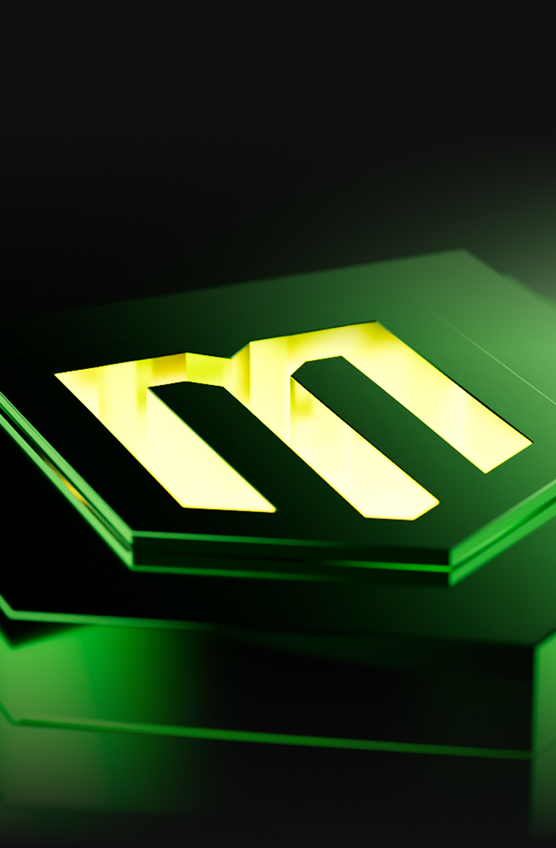 Glowing yellow letter M on layered green translucent hexagonal panels with dark background.