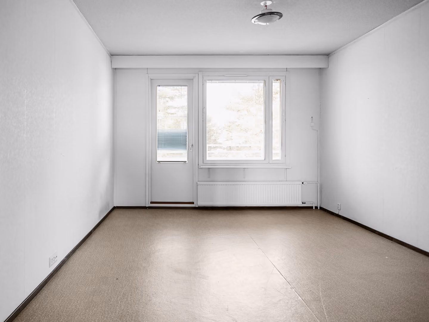 Empty room with beige floor, white walls, a window, and a door with blinds.