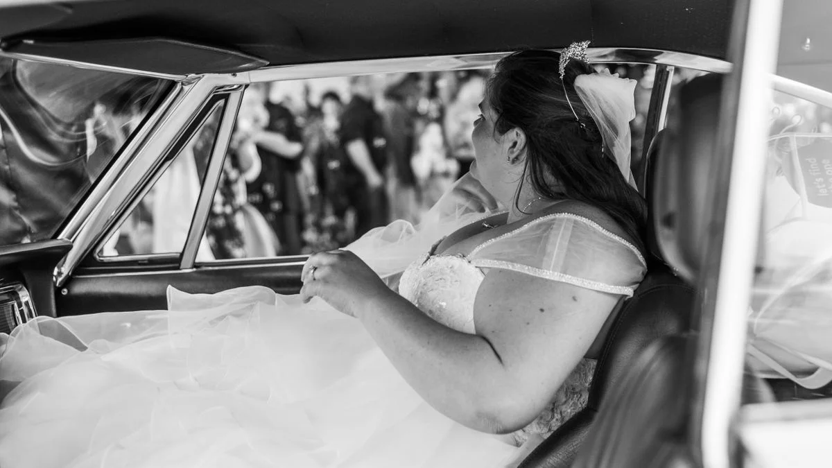 Decorated vintage wedding car parked outside a venue entrance