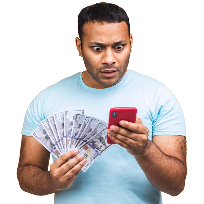 Man holding a fan of banknotes and looking at his smartphone