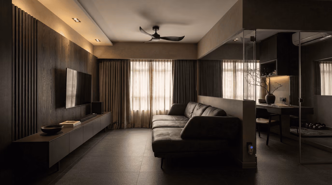 Dark modern living room with a sofa, wall-mounted TV, wooden paneling, and sheer curtains.