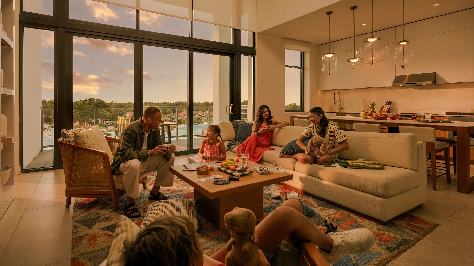 Family of five relaxing and playing with toys in a cozy living room with a large window view.