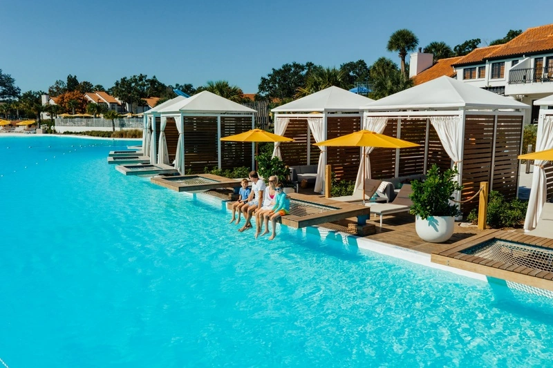 Family sitting at the edge of a private cabana on Evermore Bay
