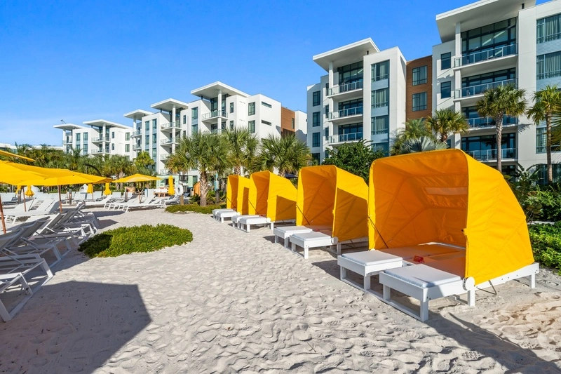Row of yellow-canopied beach daybeds on the sand at Evermore Bay