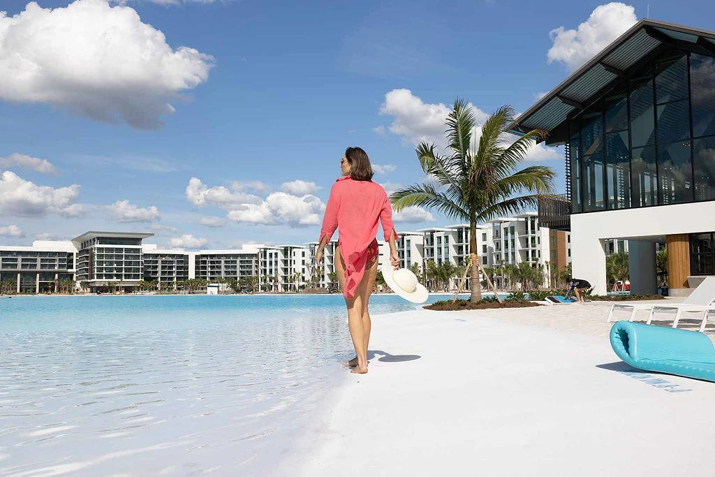 Guest walking along Evermore's white sand beach
