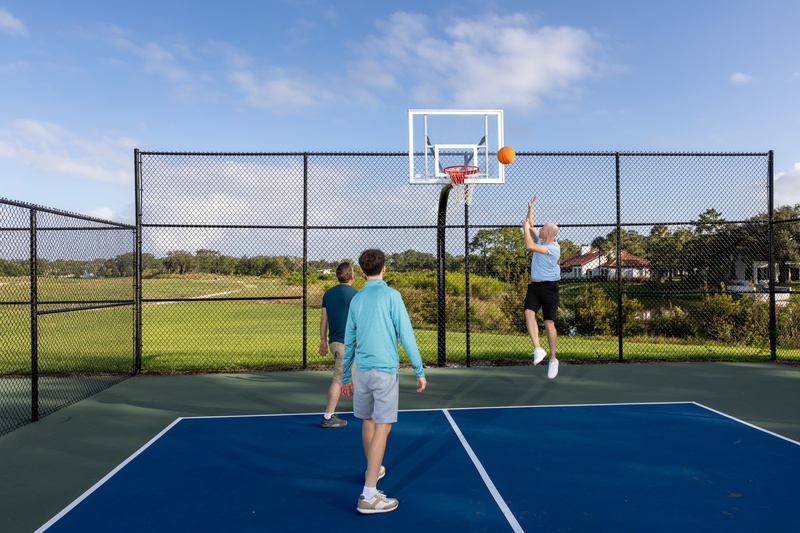 Guests playing basketball on an outdoor court at Evermore.