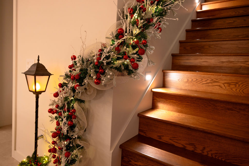 Festive holiday garland on the railing of the stairs inside a vacation home at Evermore Orlando Resort.