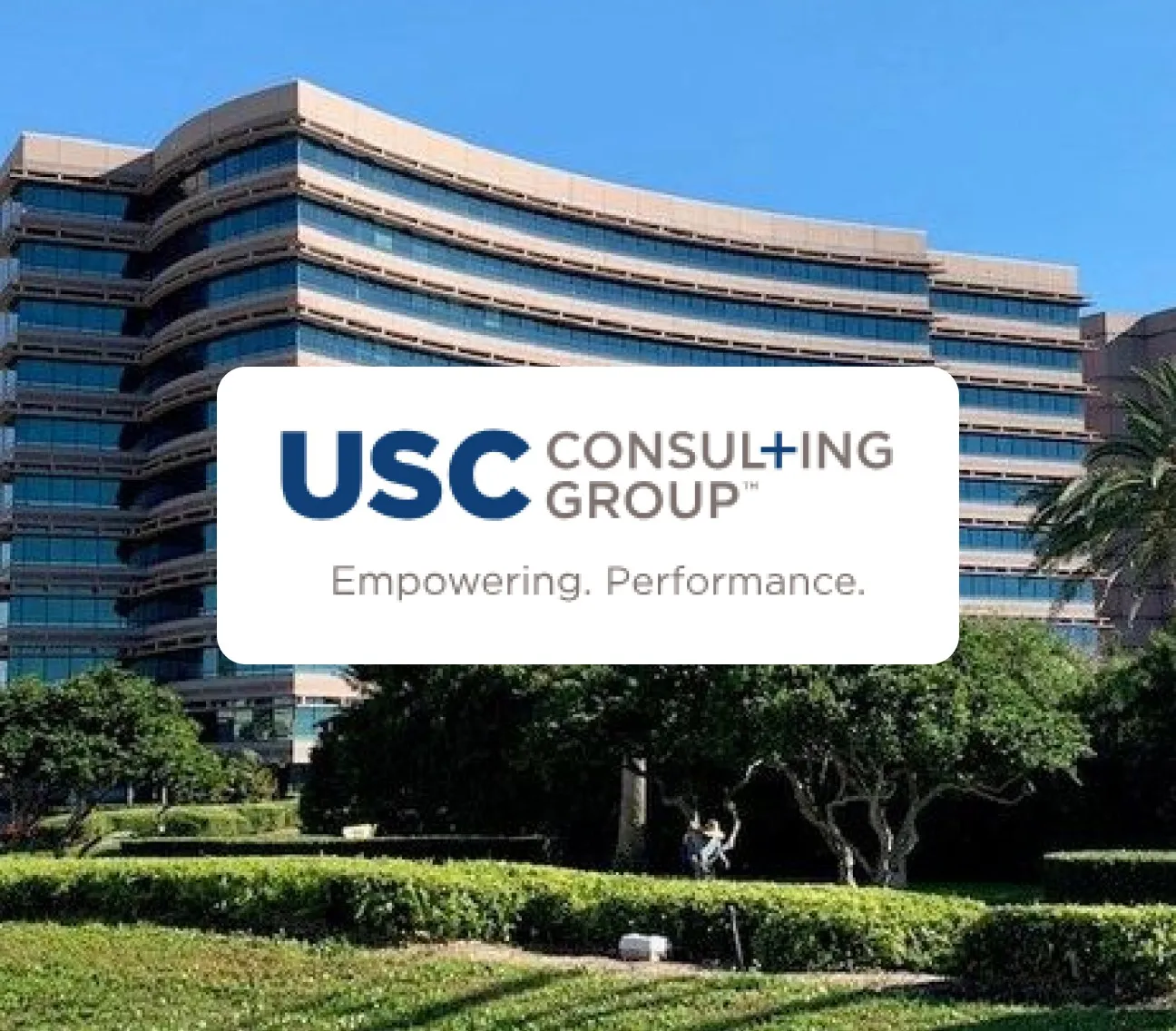Modern office building with USC Consulting Group logo and slogan Empowering. Performance.