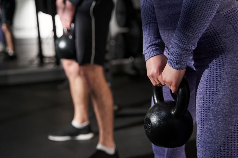 A member practicing the correct Kettlebell Swing technique with a kettlebell at a Welcome Gym to build power for the Inter Club Challenge.