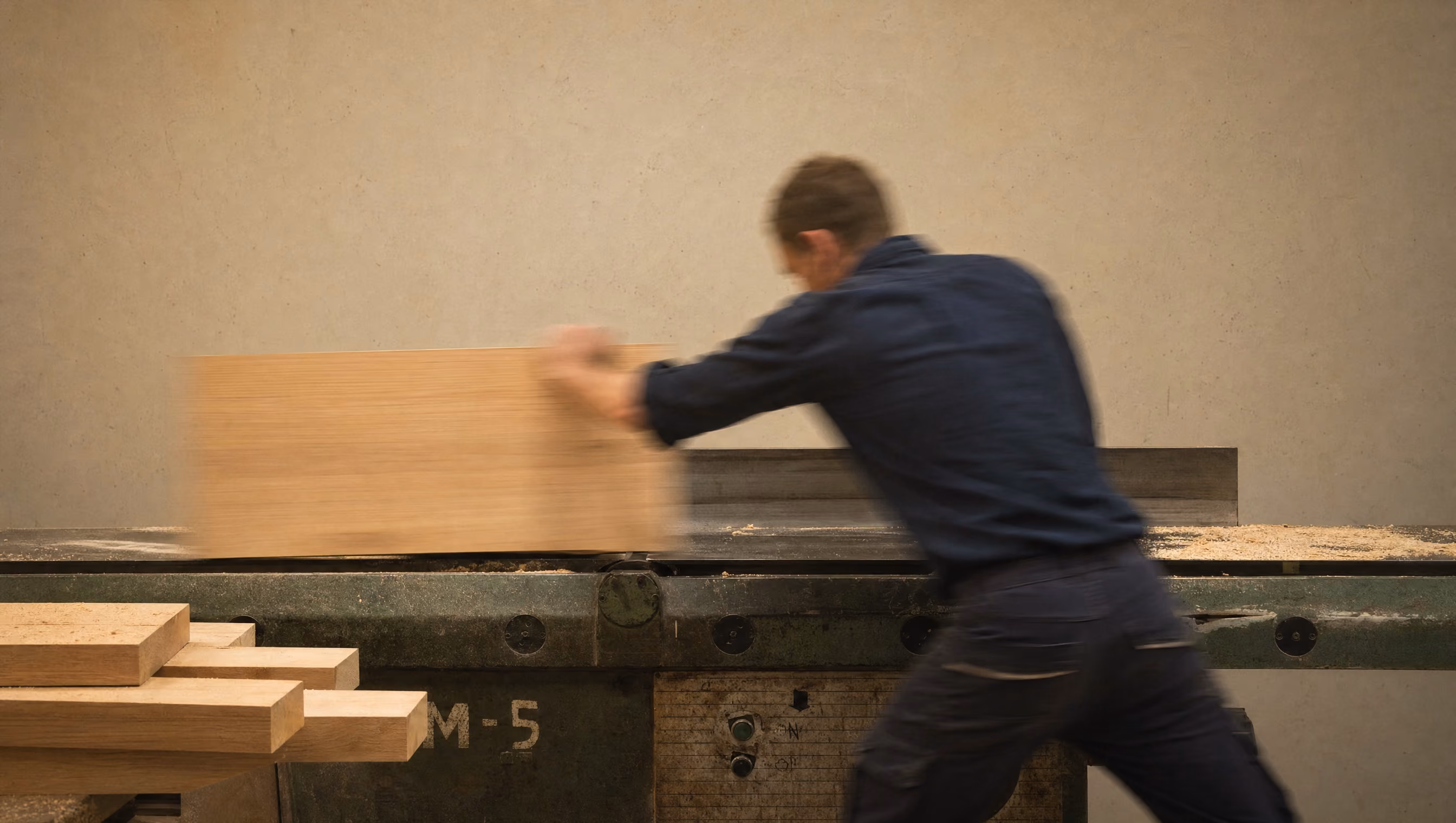 Meubelmaker schaaft een eikenhouten paneel op een machine in de werkplaats